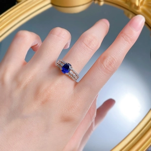 Macro shot of an oval blue gemstone ring with a triple-layered diamond-encrusted band