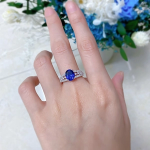Detail of S925 silver ring featuring an oval blue sapphire and pavé cubic zirconia
