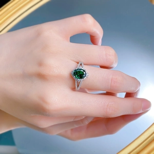 Macro view of an S925 silver ring featuring an emerald-cut green stone and split shank