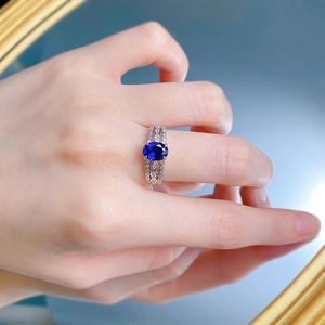 Close-up of S925 silver ring with oval blue sapphire and pavé-set zircons on hand
