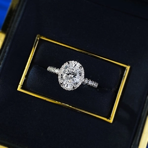 Detailed view of an oval halo diamond ring showcased in a premium navy velvet jewelry box