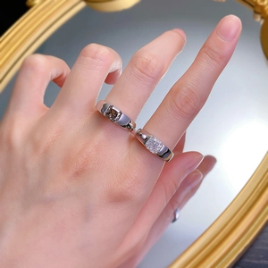 Detail of square-cut sparkling gemstone rings worn on hand reflecting in golden mirror