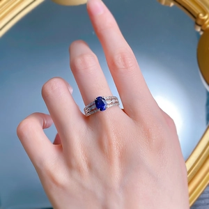 Close-up of S925 silver ring with oval blue sapphire and vintage hollow diamond band