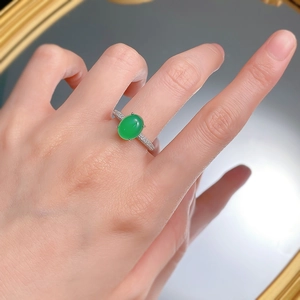 Close-up of a hand wearing a polished silver ring with a large oval green chalcedony stone