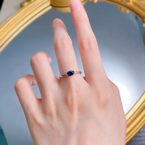 Gros plan d'une élégante bague en argent S925 avec saphir bleu sur un doigt