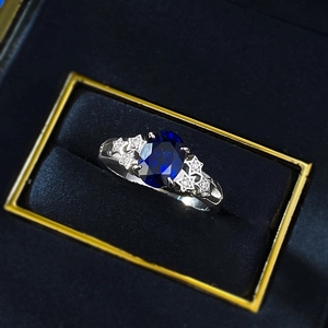 Detail of s925 silver ring featuring an oval blue gemstone and star shaped side stones