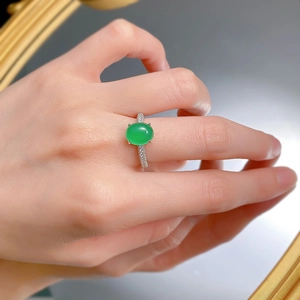 Close-up of a green chalcedony oval ring with micro-pave zircons on a hand