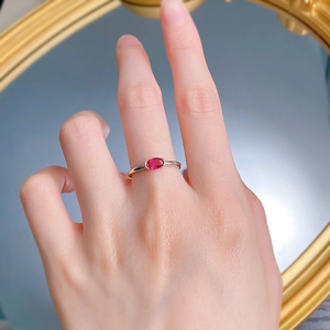 Gros plan d'une bague en argent S925 sertie d'une pierre rose ovale sur une main