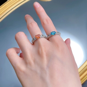 Detailed view of silver rings with leopard motif and blue and orange oval gemstones