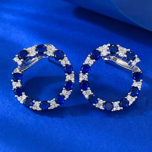 Gros plan sur des puces d'oreilles en argent S925 avec pavé de saphirs bleus et blancs