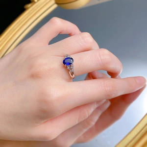 Detailed view of S925 silver ring featuring oval blue stone and star-shaped side settings