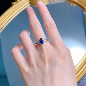 Close-up of S925 silver ring featuring oval blue sapphire and star-shaped zircon accents