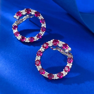 Détail macro de créoles en argent S925 avec pierres rouges et pavé de diamants blancs