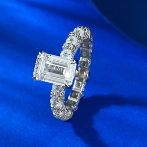 Macro view of emerald cut white diamond S925 silver ring with eternity pavé band