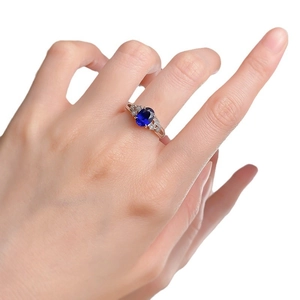 Elegant S925 silver ring with oval blue gemstone and white diamonds worn by a model