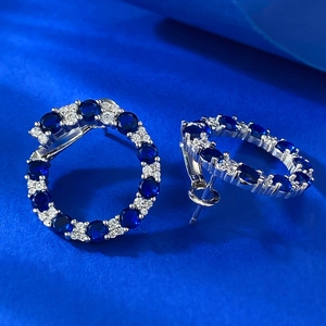 Vue détaillée des boucles d'oreilles rondes en argent aux pierres bleues et blanches