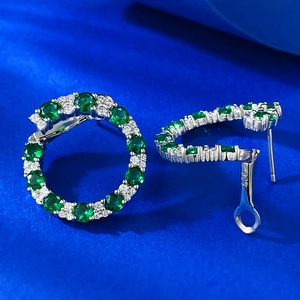 Détail macro de boucles d'oreilles en argent S925 avec poinçon 925 et oxydes verts