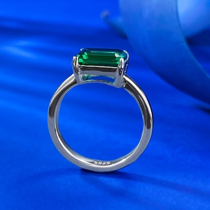 925 silver ring with rectangular emerald cut green gemstone on dark blue silk fabric