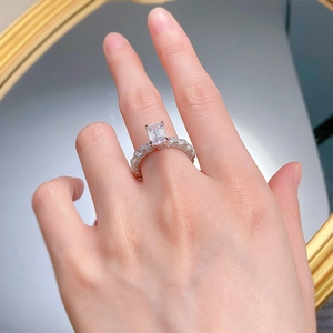Macro detail of emerald cut ring with pavé stones and silver plating on model hand