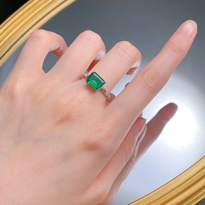 Minimalist 925 silver ring featuring rectangular emerald cut green gemstone on hand