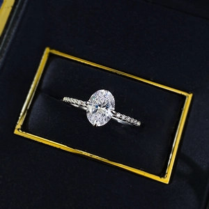 Macro detail of oval cut silver ring with pavé diamonds in a black jewelry gift box