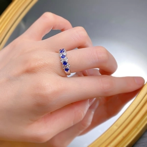 Detailansicht eines S925 Silberrings mit blauen Saphiren und weißen Steinen an der Hand