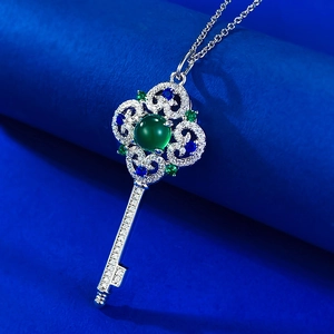 Detailed close-up of a vintage silver key pendant featuring a green chalcedony gemstone