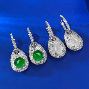 Macro shot of S925 silver water-drop earrings with green and white gemstones in 4-claw setting