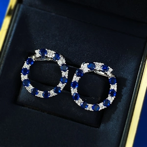 Détail macro de créoles en argent S925 avec saphirs bleus et diamants blancs