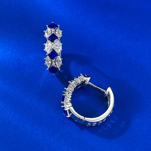 Macro view of S925 silver hoop earrings with alternating blue and white gemstones