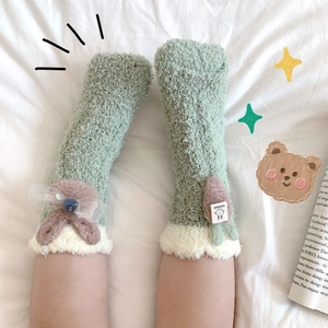 Detail of coral fleece kids socks with plush rabbit ears and cute bow decorations