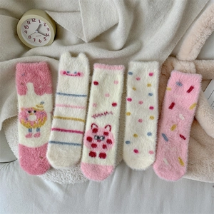 Detailed close-up of five pairs of warm coral fleece socks with cute donut patterns