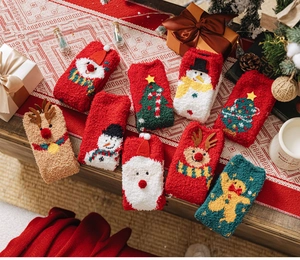 Macro shot of 9-pair Christmas coral fleece socks set with reindeer and Santa patterns
