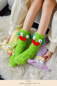 Detail of colorful fuzzy monster socks in coral fleece featuring quirky 3D eyes and lips