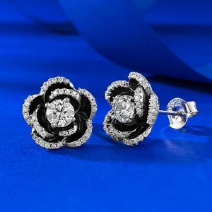 Macro shot of S925 sterling silver camellia stud earring with black enamel and diamonds