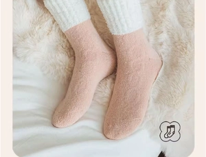 Gros plan sur des chaussettes thermiques en polaire corail rose doux avec texture peluche