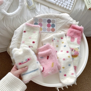 Detail of plush coral fleece thermal socks with cute donut and smiling face patterns