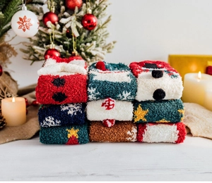 Close-up of fluffy Christmas coral fleece socks with festive snowman and reindeer patterns