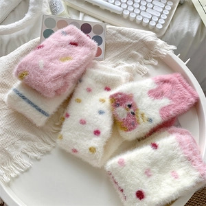 Detail of plush coral fleece thermal socks with cute cat patterns and cozy soft texture