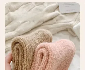 Gros plan de chaussettes thermiques en laine épaisses en kaki et rose à texture polaire