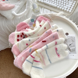 Detail of soft coral fleece thermal socks in pink and white stripes on a tray