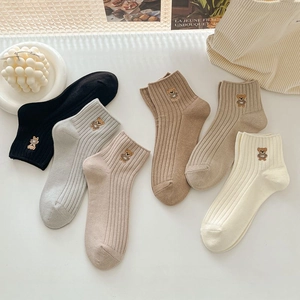 Gros plan détaillé de chaussettes en coton côtelé avec broderie d'ours mignonne