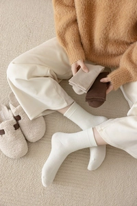 Detailed texture of thick ribbed cotton mid-calf socks in warm earth tones for winter