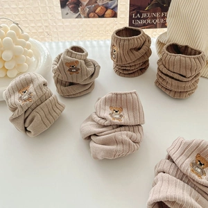 Détail du tissu tricoté à côtes avec broderie d'ours mignonne sur des chaussettes