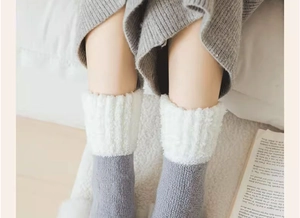 Détail de chaussettes thermiques en laine grise avec revers en polaire blanche