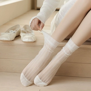 Detailaufnahme cremefarbener Spitzen-Rippstrick-Socken auf Holzstufen