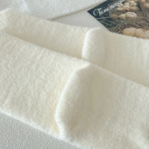Close-up of soft white fleece material and cozy knit texture on winter thermal socks