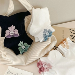 Detailed view of floral embroidery on cotton ankle socks in various vibrant colors