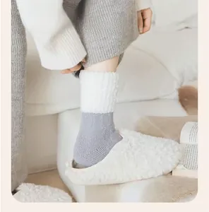 Détail de chaussettes thermiques en maille grise et pantoufles en peluche blanche