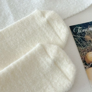 Close-up of thick creamy fleece socks showing fluffy texture for winter warmth